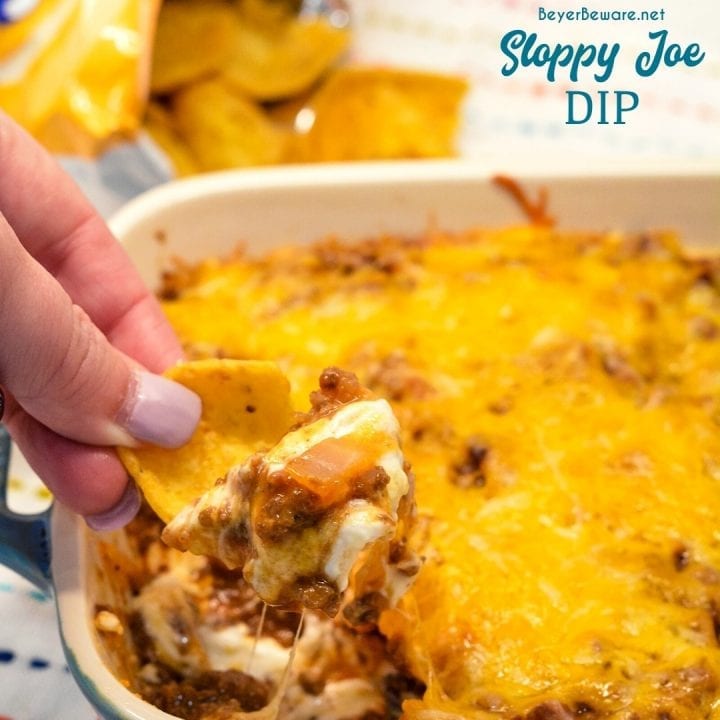 Sloppy Joe Dip has a cream cheese base and topped with an easy sloppy joe ground beef mixture and topped off with shredded cheese and onions, baked to a gooey, meaty goodness and then scooped up with corn chips.