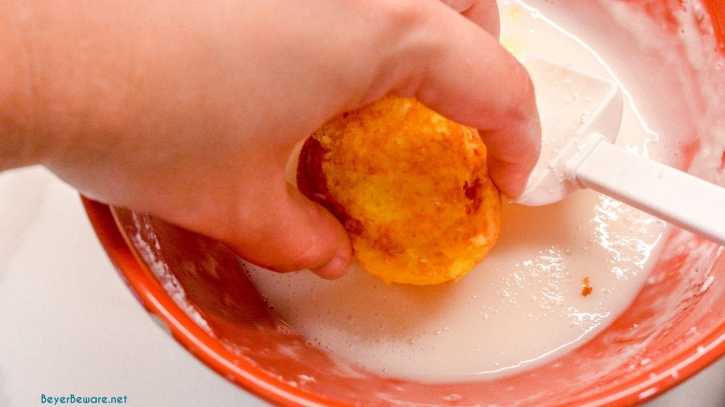 Dipping mini lemon cupcakes in lemon glaze.