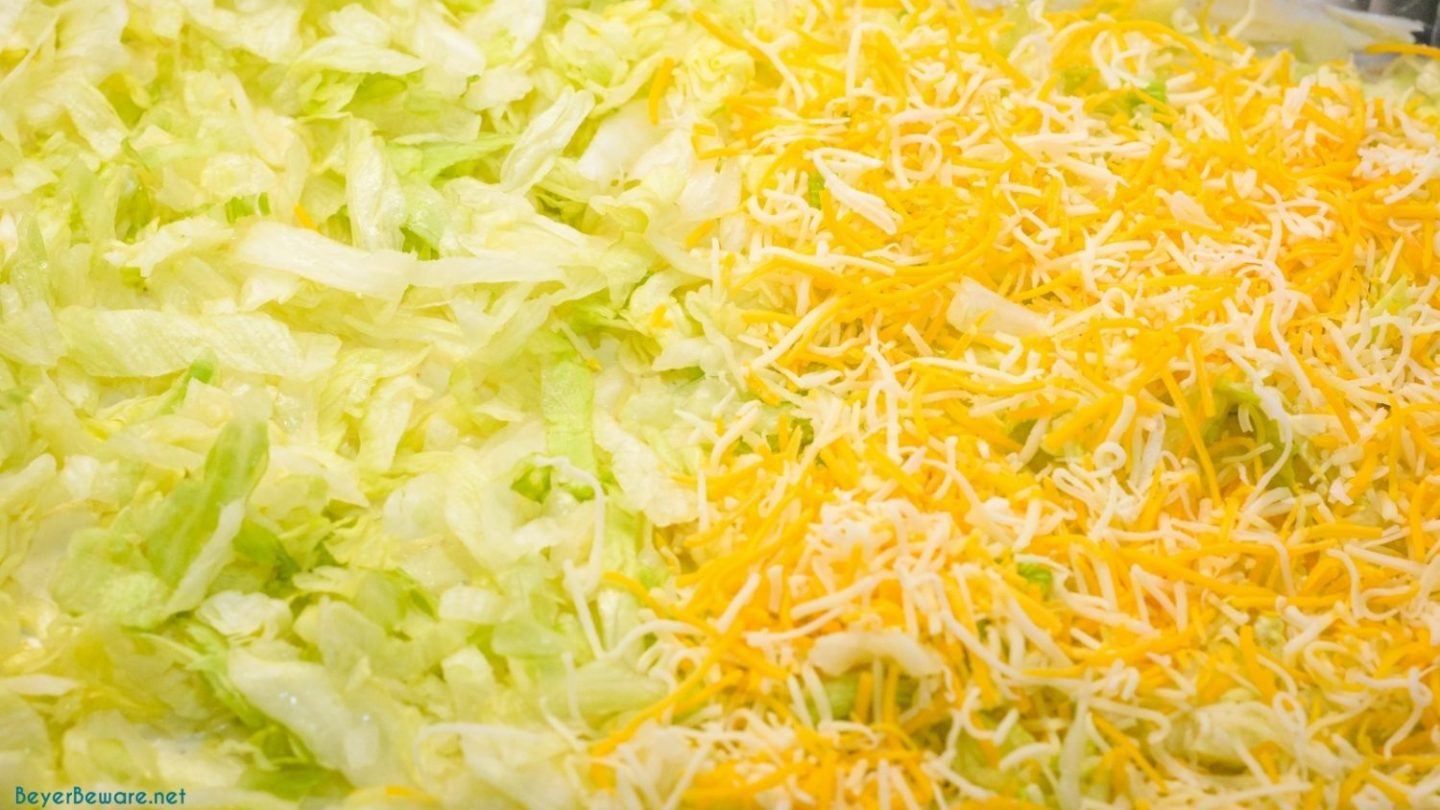 Lettuce and shredded cheese layer of the 7 layer dip.