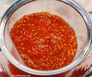 Straining tomato seeds for the juice