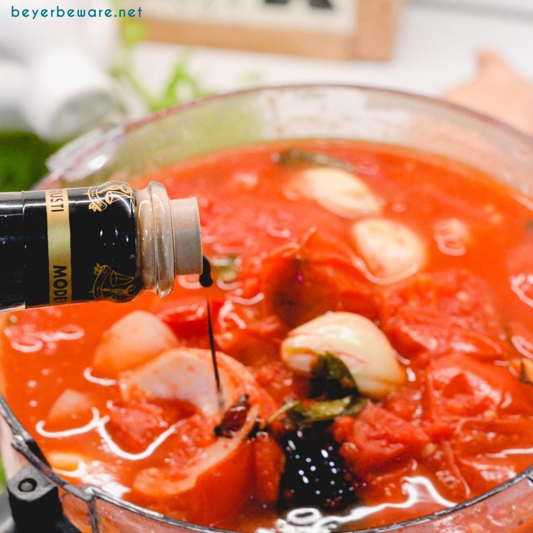 Adding balsamic vinegar to tomato sauce.