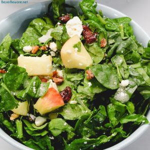 Apple spinach salad is a sweet and savory mixture of spinach, apples, pecans, cranberries, and feta cheese finished with a maple dijon vinaigrette.