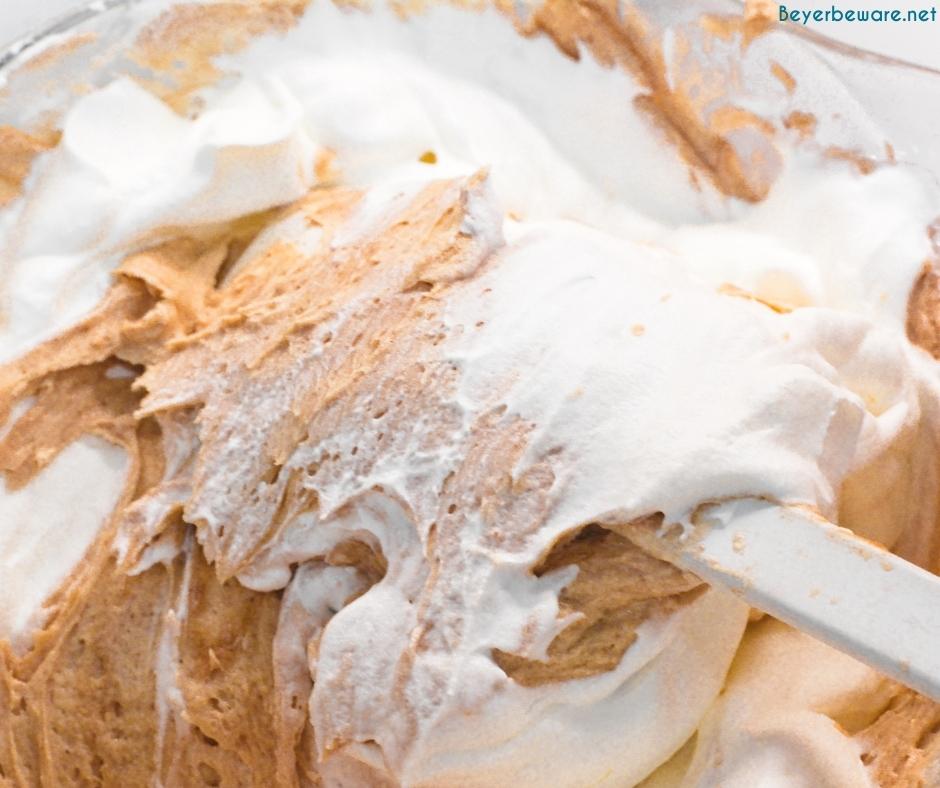 Folding in whipped cream into the cream cheese peanut butter filling for no-bake peanut butter pie.