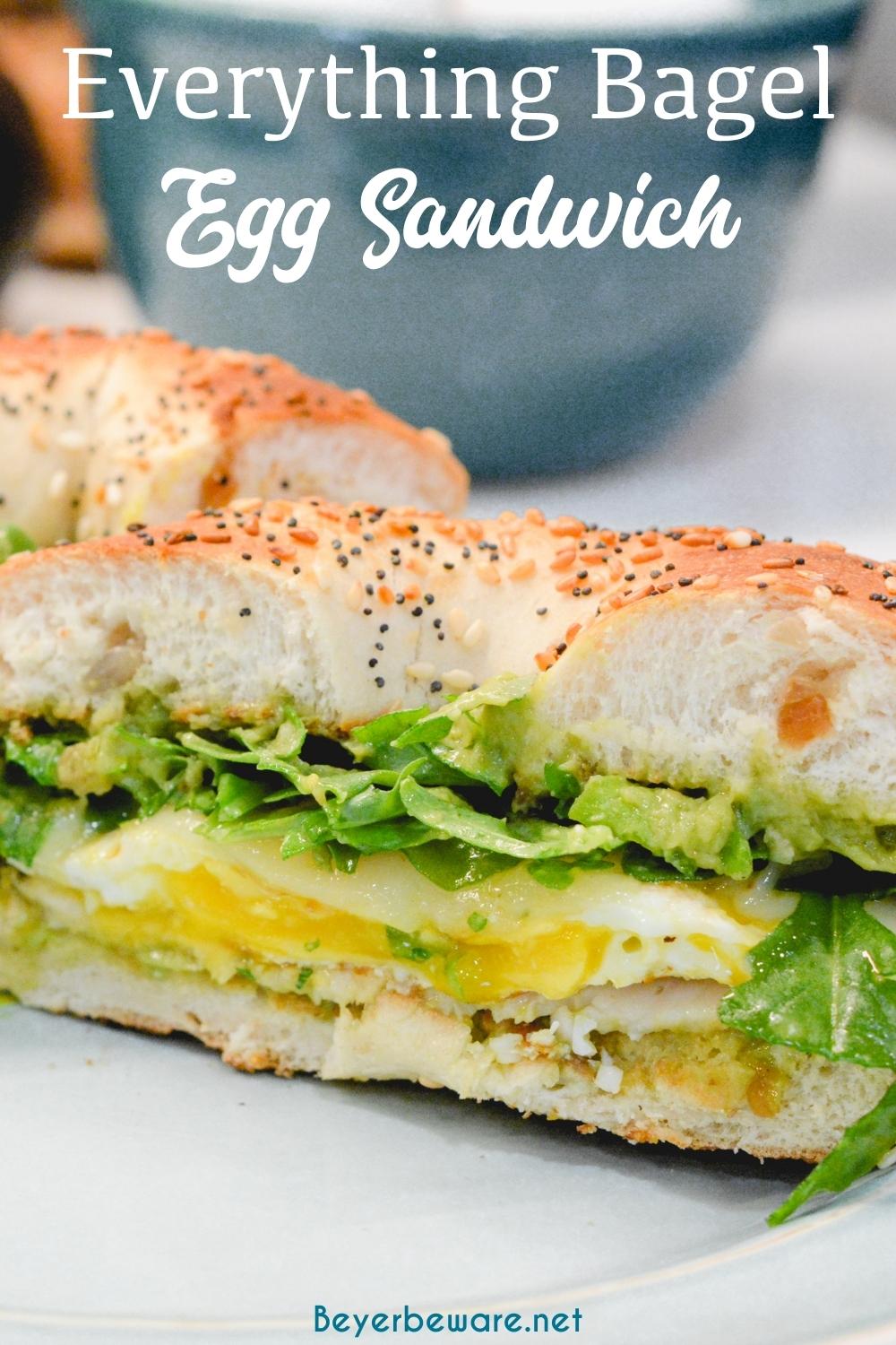 This everything bagel egg sandwich is filled with avocado, turkey, egg, cheese, and topped off with arugula. 