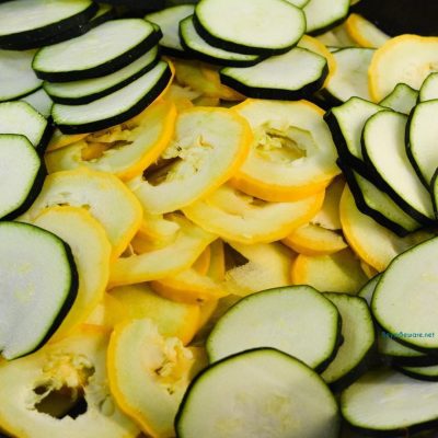 Thinly slice the squash, both zucchini and yellow summer squash. Add to a skillet that has melted butter in it with the onions and garlic.