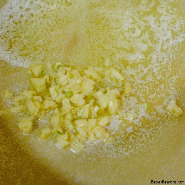 Start by melting butter in the saucepan. Add the minced garlic to the butter and saute. 