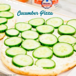 Cucumber pizza is a simple no-bake appetizer made with naan bread, cream cheese, Italian seasoning, and cucumbers cut into cucumber bites.