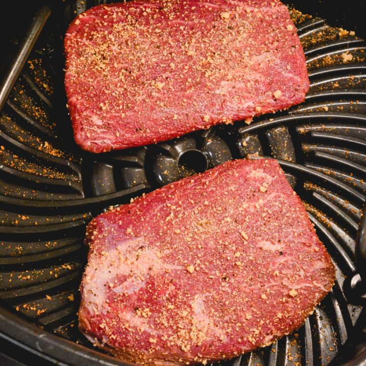 Season both sides of the steak. When the air fryer is hot, grease the pan and lay the steaks in the air fryer.