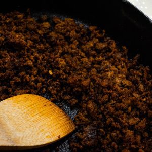 In a cast iron skillet, brown the beef chorizo until cooked fully. Break up into small pieces.