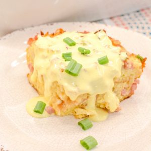 Eggs Benedict casserole that is made with English muffins, ham, eggs, and topped off with an easy blender hollandaise sauce.