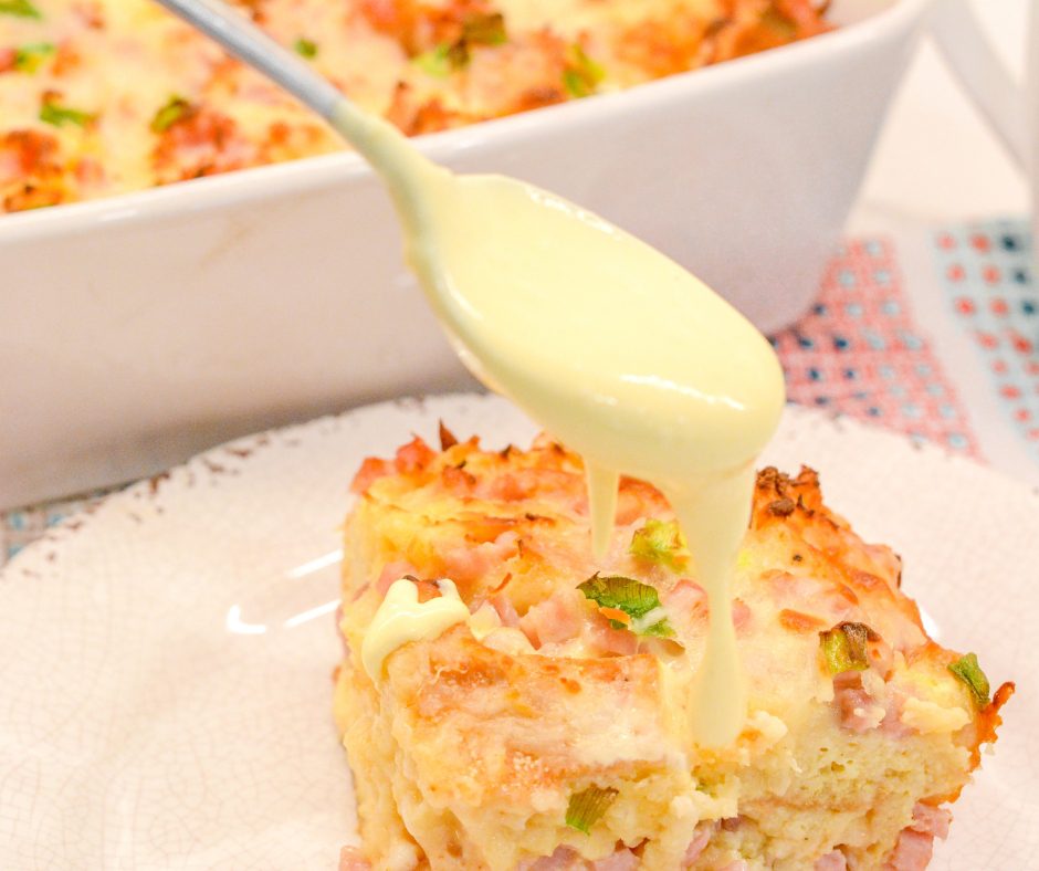 Eggs Benedict casserole that is made with English muffins, ham, eggs, and topped off with an easy blender hollandaise sauce.