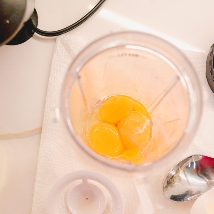 In a blender cup, add egg yolks, lemon juice, and melted butter.