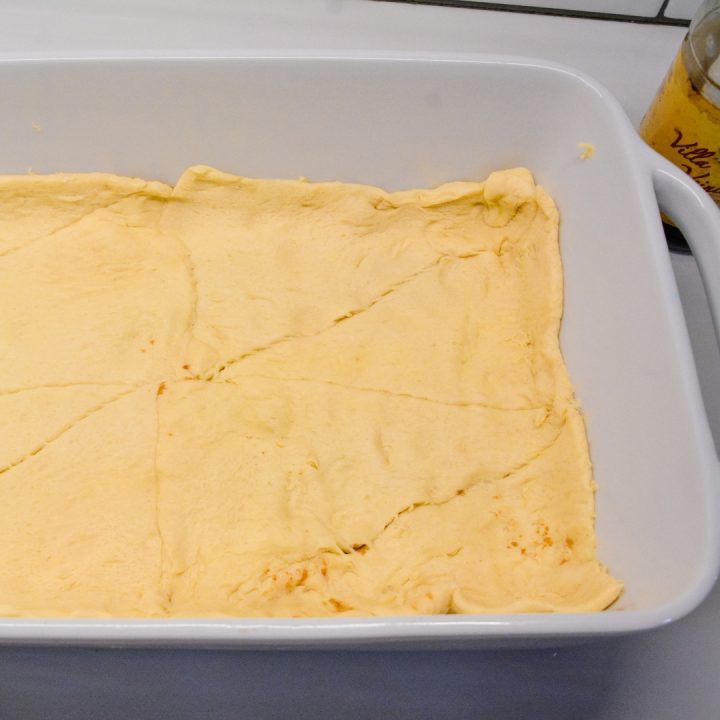 Then roll out one of the tubes of crescent rolls over the butter and cinnamon and sugar.