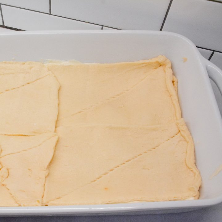 Top the cream cheese layer with the other tube of crescent rolls.