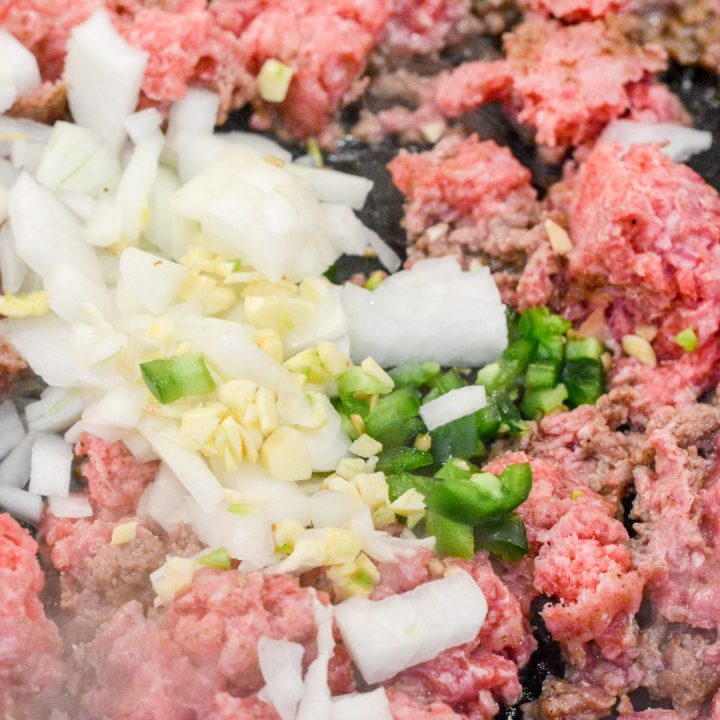 Brown the hamburger in the skillet with diced onion, garlic, and jalapeno. Season with taco seasoning.