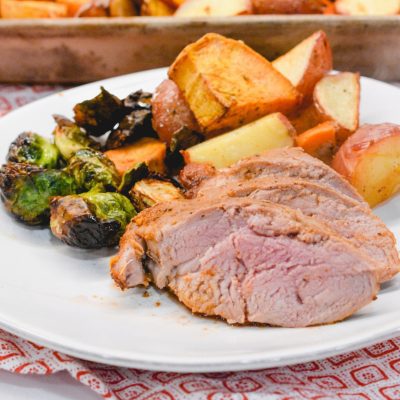 The sheet pan pork tenderloin is rubbed in a sweet and spicy dry rub that is sprinkled on the cut-up sweet potatoes, red potatoes, and Brussels sprouts before it is oven baked.