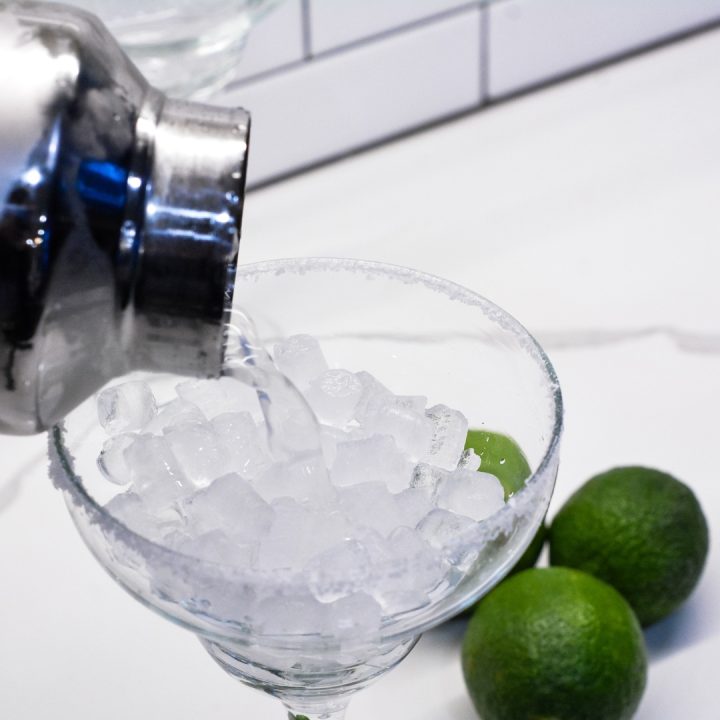 Add ice to the margarita glasses and pour the shaken margaritas through a strainer over the ice.