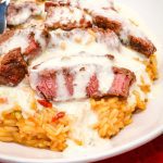 Arroz Con Carne Asada is the beef steak version of the popular arroz con pollo recipe that is quickly made at home with Mexican rice, steak, and queso cheese.