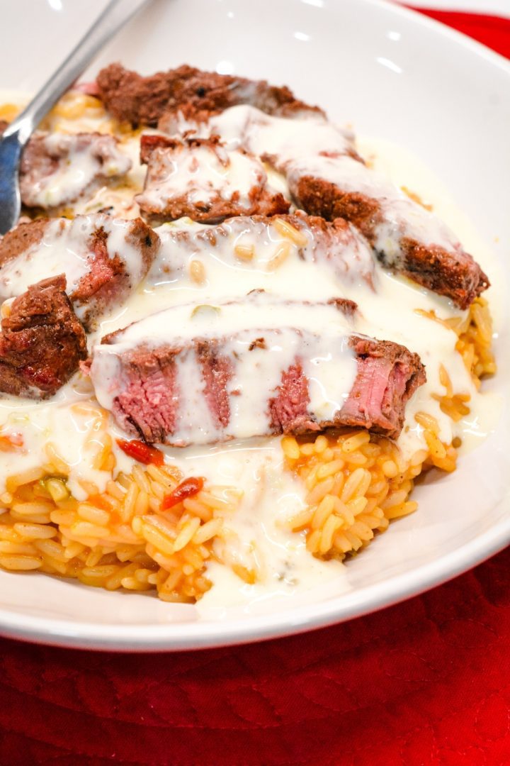 Arroz Con Carne Asada is the beef steak version of the popular arroz con pollo recipe that is quickly made at home with Mexican rice, steak, and queso cheese.