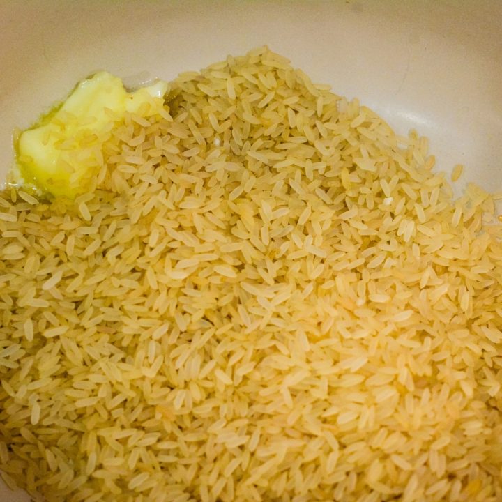 Begin to make the rice for the arroz portion by melting butter in a sauce pan and then brown the rice for 2-3 minutes.
