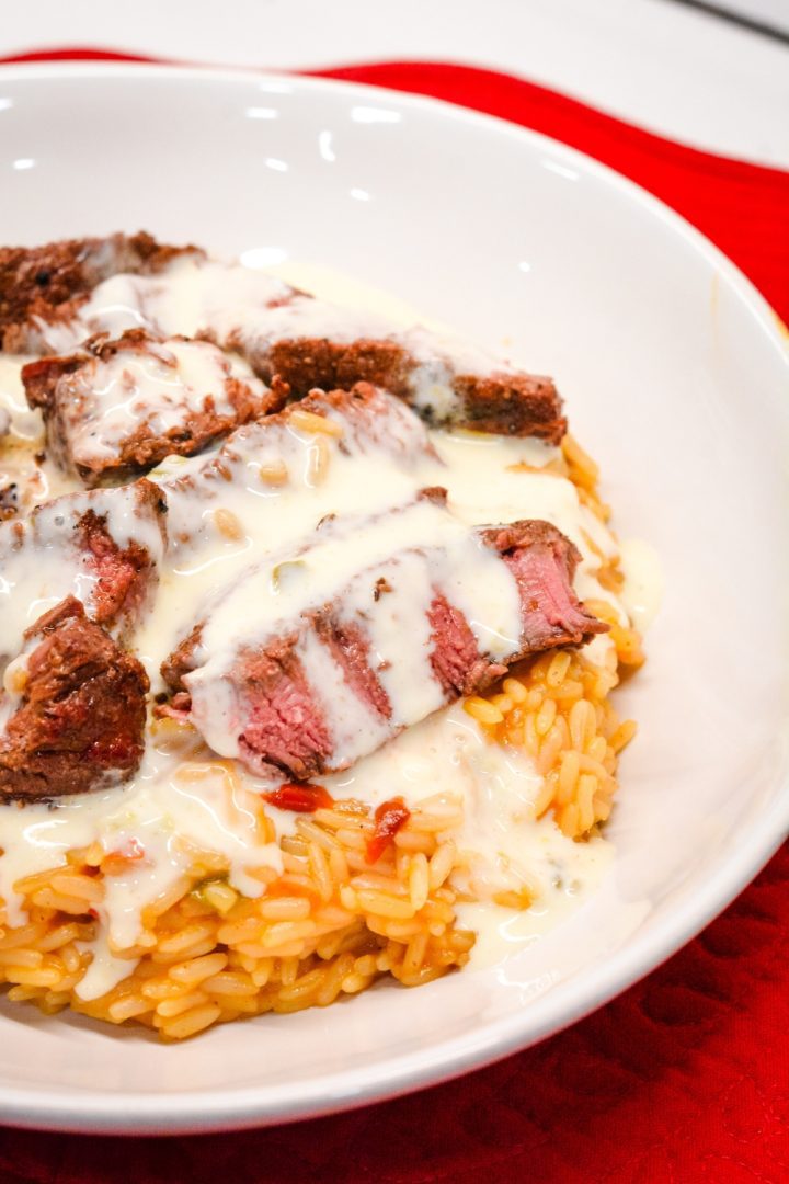 Arroz Con Carne Asada is the beef steak version of the popular arroz con pollo recipe that is quickly made at home with Mexican rice, steak, and queso cheese.