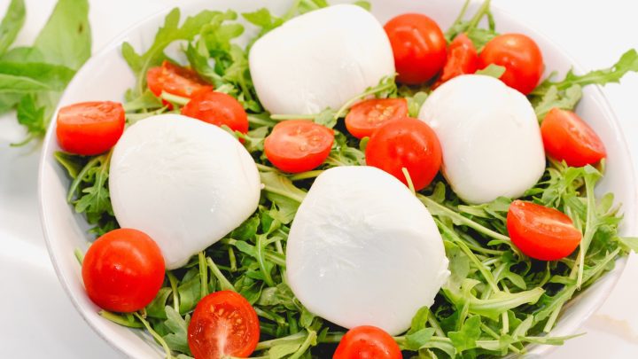 Lay the washed arugula in a shallow bowl. Then lay the burrata, prosciutto, and tomatoes over the arugula.