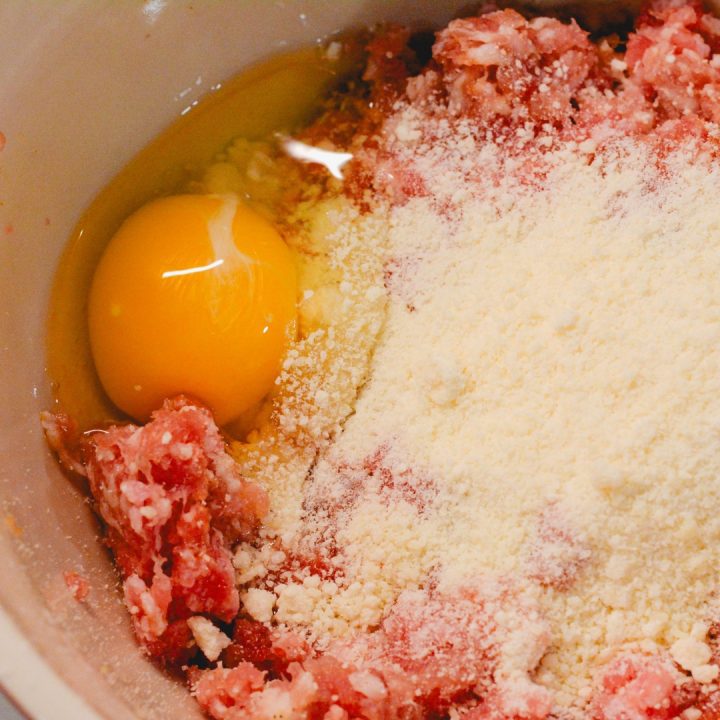 Next, add the egg and parmesan cheese to the ground pork mixture. Mix completely together incorporating the egg and cheese completely.