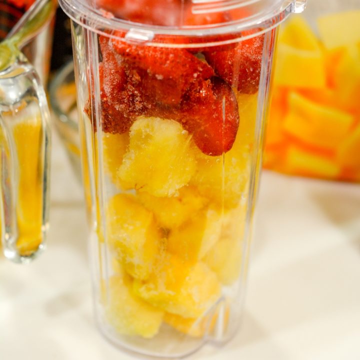 Combine the three frozen fruits in a blender or blender cups.