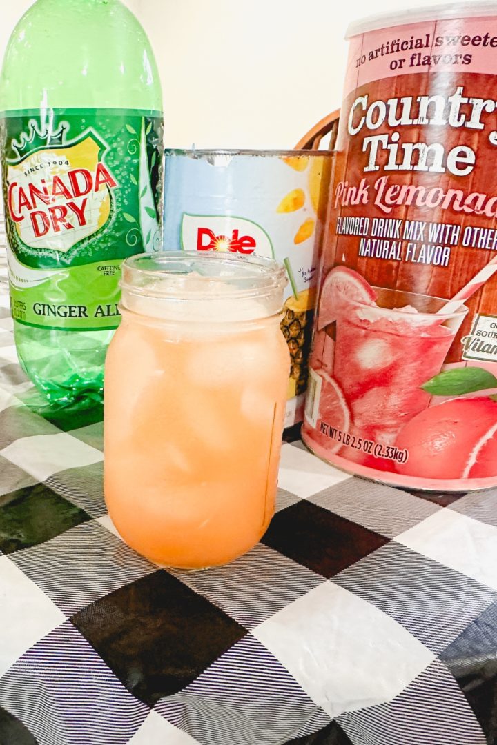 When the pink Country Time lemonade is mixed with the yellow of the pineapple juice, a fun orange punch is created with this pineapple lemonade punch that is slightly tart, and slightly sweet with a little fizz from ginger ale.