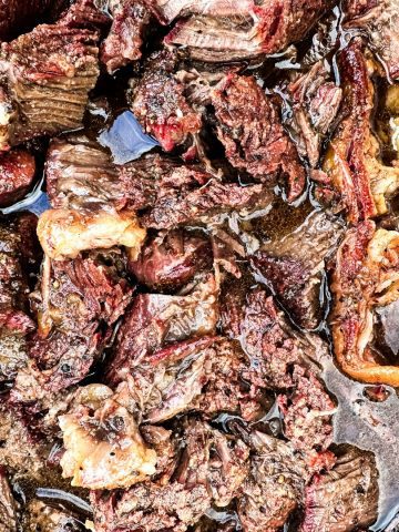 Smoked beef chuck roast will quickly become one of your favorite cuts of beef to smoke with a simple beef rub made with garlic, salt, and pepper and then finished in a pan of onions and beef broth.