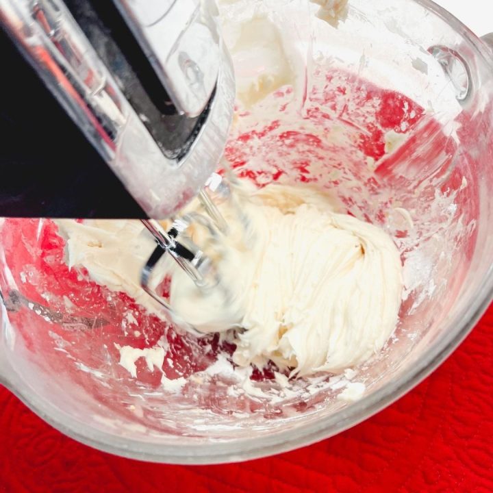 Gradually introduce the powdered sugar into the cream cheese, continuing to mix until the sugar is fully incorporated. This step brings the necessary sweetness reminiscent of a classic cheesecake.