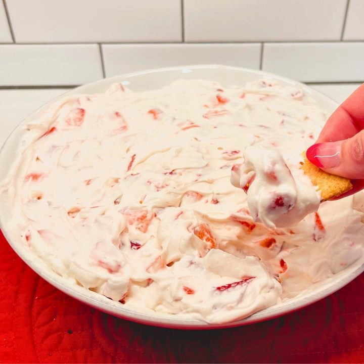 Strawberry Cheesecake Dip is a no bake cheesecake dessert made with cream cheese, whipped cream, powdered sugar, and fresh strawberries.