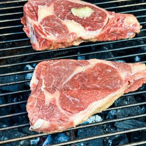Place the steaks directly over the high-heat side of the grill. Sear them for about 2-3 minutes per side with the lid closed. This will give them a beautiful crust. I do not season the steaks before placing them on the grill.