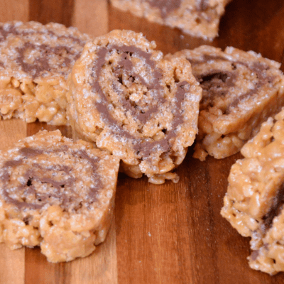 These scotcharoos pinwheels combine the crispy rice cereal, peanut butter, sugar, and corn syrup for the base and then topped and rolled with melted butterscotch and chocolate. 