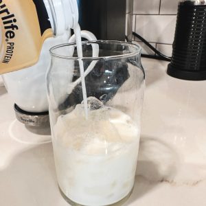 Fill a glass with ice cubes, leaving enough room at the top for your coffee and protein milk mixture. Pour part of the Fairlife Vanilla Power Core Shake over the ice.