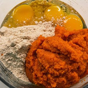In a large mixing bowl, combine the spiced cake mix, pumpkin puree, eggs, and water. Mix the ingredients until well combined, but avoid over mixing.