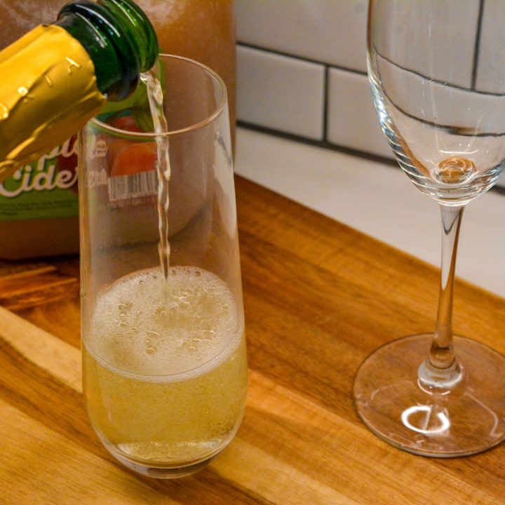 Fill a champagne flute half full with champagne or sparkling wine.