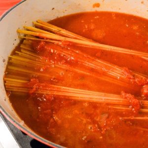 Add the spaghetti noodles, tomato sauce, and water to the pan.