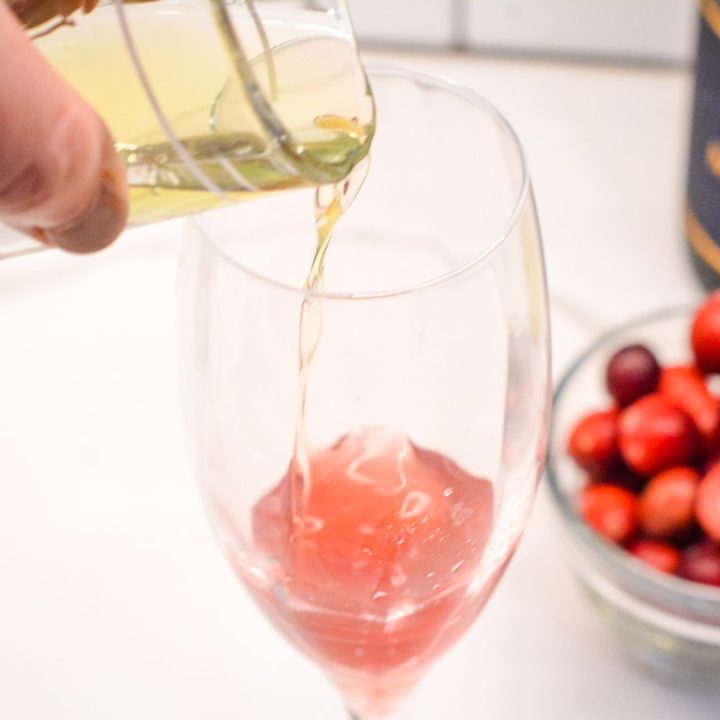 pour the cranberry juice and limoncello into a champagne flute or Colins glass and stir to combine.