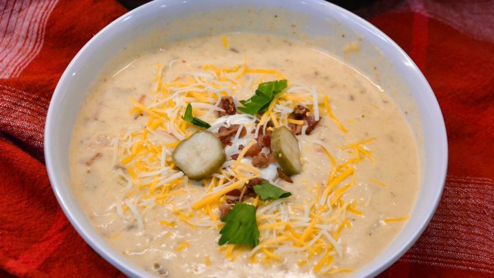 Crock pot bacon cheeseburger soup is potato soup recipe slow-cooked all day in a base of carrots, celery, onions, and garlic along with diced potato hashbrowns, ground beef, bacon, and cream cheese that just needs shredded cheddar cheese and white sauce added before serving for dinner.