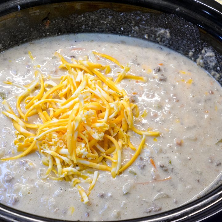 Make a small batch of white sauce with butter, flour, and milk. Stir it into the soup along with the shredded cheese. Finish off with sour cream.