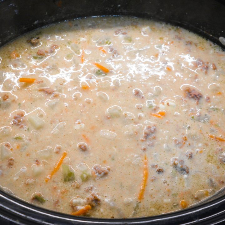 Cook the bacon cheeseburger soup on low for four hours. Stir the cream cheese into the soup mixture. While the soup is cooking, shred up the cheese of your choice.