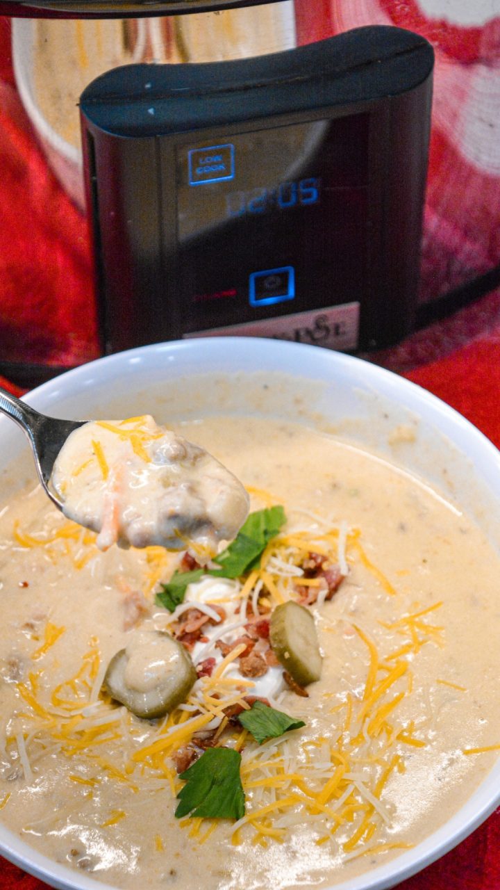 Crock pot bacon cheeseburger soup is potato soup recipe slow-cooked all day in a base of carrots, celery, onions, and garlic along with diced potato hashbrowns, ground beef, bacon, and cream cheese that just needs shredded cheddar cheese and white sauce added before serving for dinner.