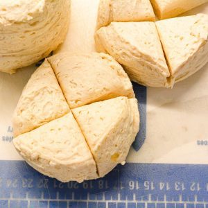 Pop open the cans of biscuits and removing them from the can. Then cut into four quarters. Put them in a large bowl and set aside.