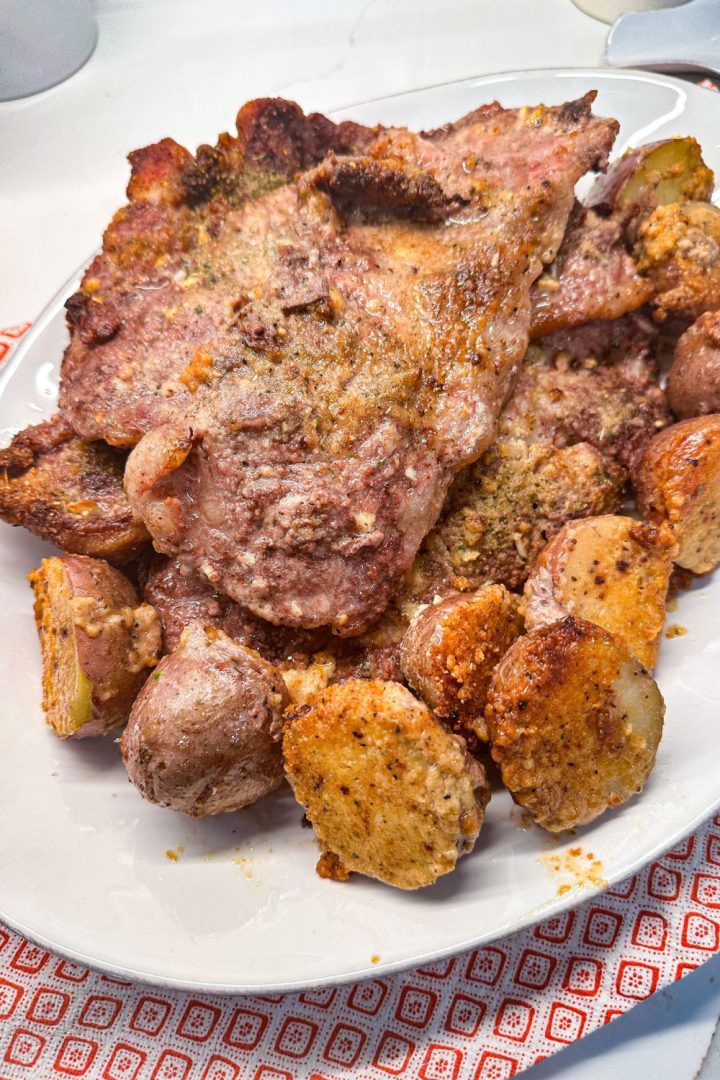 Crispy parmesan crusted potatoes and pork steak are an easy sheet pan meal that can be prepped ahead of time and stored in the fridge or freezer until meal time.