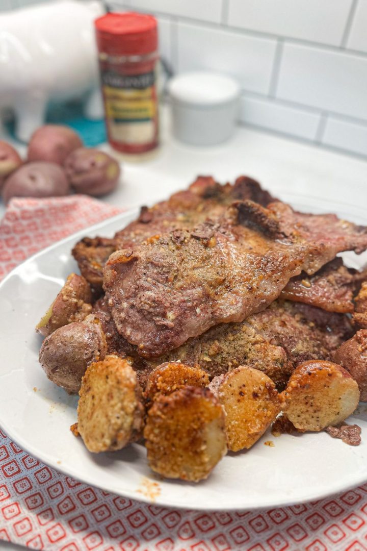 Crispy parmesan crusted potatoes and pork steak are an easy sheet pan meal that can be prepped ahead of time and stored in t