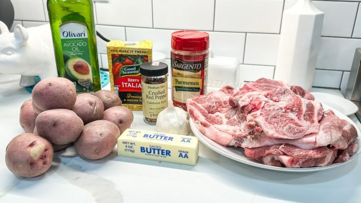 Parmesan potatoes and pork steak ingredients - red potatoes, buttter, avocado oil, Italian dressing seasoning, parmesan cheese, red pepper flakes, pork should steaks