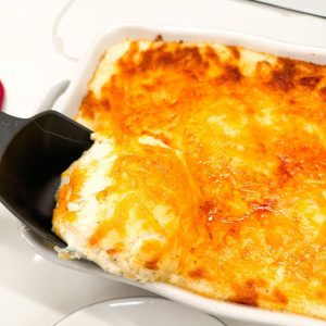 Mashed potato casserole is made with potatoes, cream cheese, sour cream, and French fry seasoning and topped off with shredded cheddar cheese make the ultimate party potatoes.