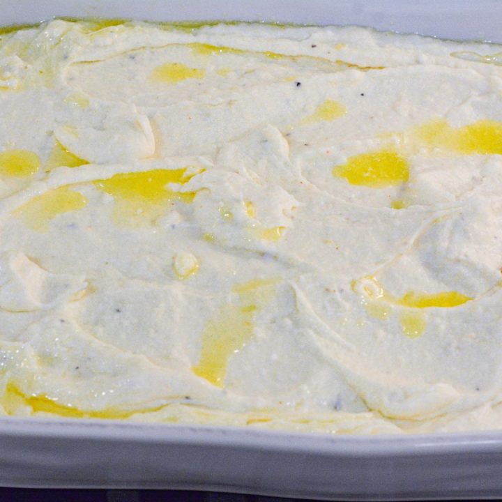 Spread the creamy mashed potato base into a greased casserole dish or 13x9 baking dish. Top off with melted butter. 