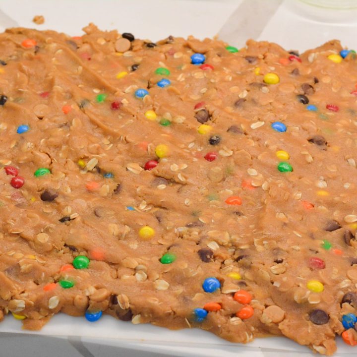 Either spread out the cookie dough on a cutting board mat and then place it on the partially baked brownie layer or drop in smaller flat pieces on the brownies.